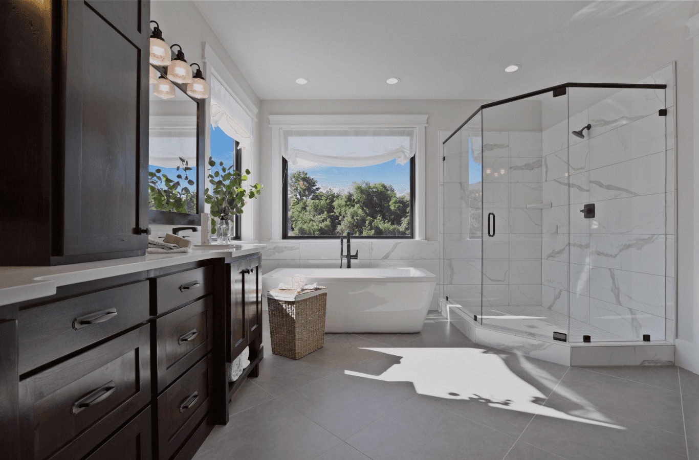 Master bathroom with dark wood double vanity, freestanding tub, and corner glass shower