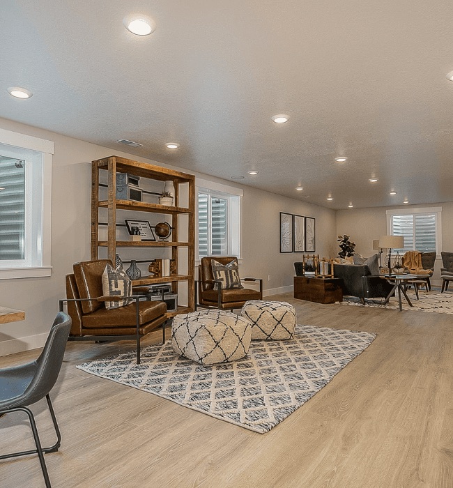 Finished basement lounge with leather chairs and luxury vinyl plank flooring