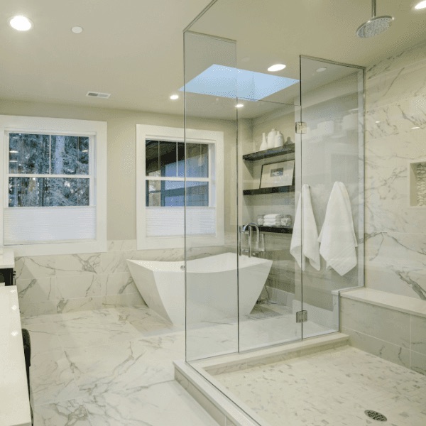 Bright remodeled bathroom with freestanding tub and glass shower