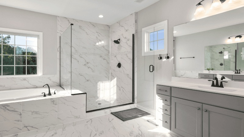 Marble-tiled bathroom with glass shower, an example of skilled renovation craftsmanship
